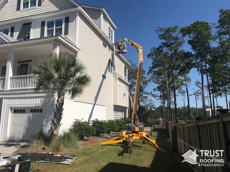 Trust Roofing & Restoration team using an articulating basket to access a roof in Wilmington, NC
